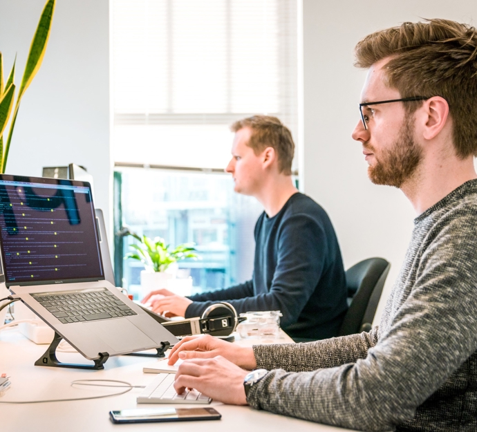To personer arbejder ved computere